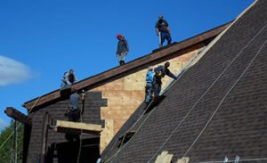 Men standing on dome while installing a roof on it