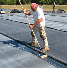 Man installing EPDM rubber on roof