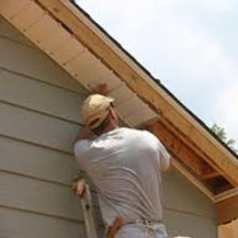 Man installing soffit on house